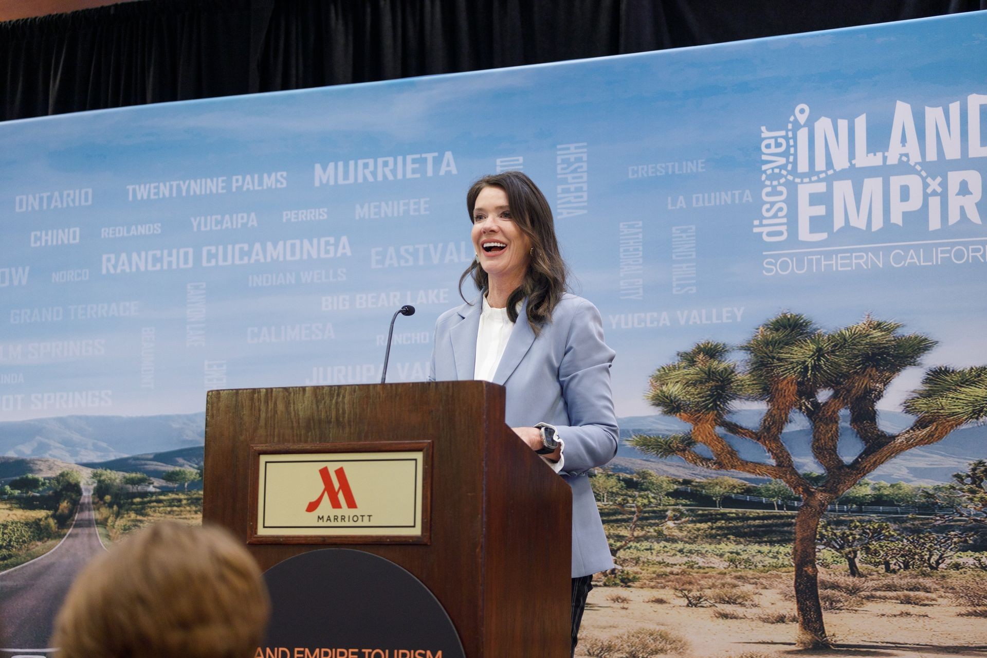 woman speaking at podium at corporate conference